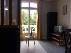 迪纳尔Dinard: studio à 100 m de la plage de L'Ecluse的客厅配有桌子和窗户