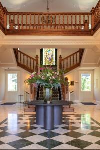 圣塞瓦斯蒂安索罗别墅酒店的大堂设有一张桌子,上面有花瓶