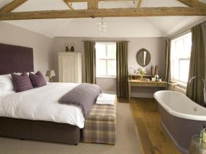 吉尔福德珀西阿姆斯酒店的一间卧室设有一张大床和一个浴缸