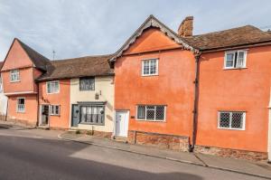 拉文纳姆Extraordinary 15th Century timber framed cottage in famous Medieval village - The Tryst的街道边的橙色房子