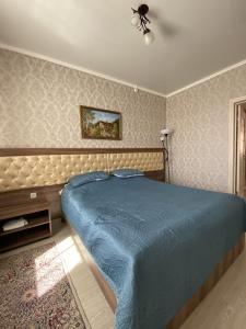 博罗沃耶AL BARAKA的一间卧室配有蓝色的床和吊扇