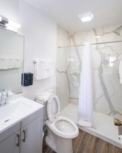 斩魔山Outer Banks Motor Lodge的白色的浴室设有卫生间和淋浴。