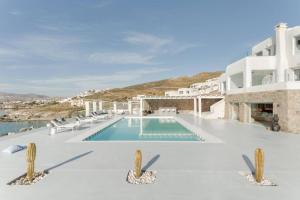 圣爱奥尼斯米科诺斯Villa Goddess by Whitelist Mykonos的一座带椅子的游泳池以及一座建筑