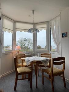 达默FeWo Seeschloss Nr 5的一间带桌椅和窗户的用餐室