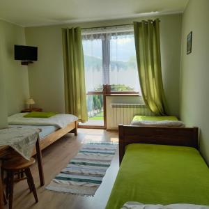 什恰夫尼察Willa Bańkoszówka的一间小卧室,配有两张床和窗户