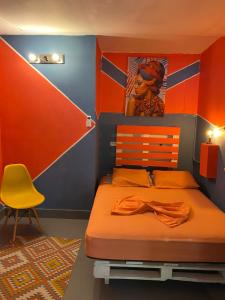 巴拿马城席步罗旅舍的一间卧室配有一张床和一张黄色椅子