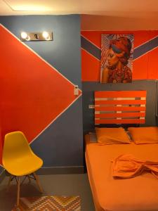 巴拿马城席步罗旅舍的一间卧室配有橙色的床和黄色椅子