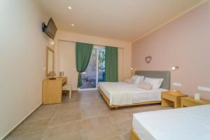 拉多斯Amaryllis front beach hotel的一间卧室设有两张床和窗户。