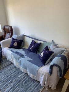 莱姆里吉斯Lovely well equipped apartment - 2 bedroom, sleeps 4, sundeck, 8 min river walk to beach and town, FREE parking permit !的一张沙发,上面有蓝色枕头