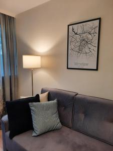 弗罗茨瓦夫Apartament w centrum Wrocławia的客厅配有沙发和墙上的照片