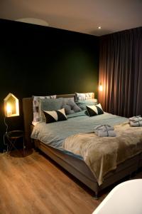 瓦尔韦克Bed and Breakfast in de buurt的一间卧室设有一张大床和绿色的墙壁
