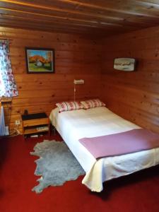 艾尔夫达伦Mysig stuga i Vasaloppsbyn Evertsberg的木制客房内的一间卧室,配有一张床