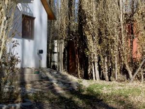 马拉圭Los Abedules Bungalow的白色的房子,有门和一些树木