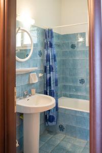 扎戈拉Eleni's House Chorefto的蓝色瓷砖浴室设有水槽和浴缸