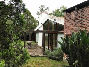 圣洛伦索Lindísima casa de campo en Villa San Lorenzo Salta的一座带玻璃窗的房子和砖砌建筑