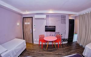 萨尔瓦多B酒店的小房间设有桌子和两把椅子