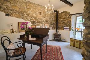 ArnascoAgriturismo Le Merline的一间设有钢琴、桌子和椅子的客房