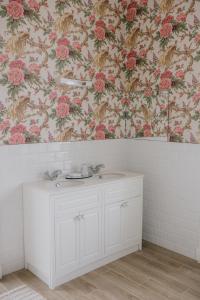 卡舍尔Noan Country House B&B的浴室设有白色水槽和花卉壁纸