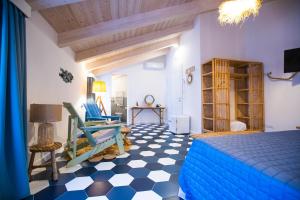 圣尼科拉阿尔切拉Suitetti Camere&Relax的一间卧室设有蓝色的床,铺有 ⁇ 木地板