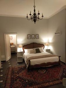 热那亚Dimora Caffaro的一间卧室配有一张大床和一个吊灯。