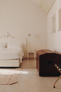 GiuggianelloMasseria Petrusella的白色卧室配有床和桌子