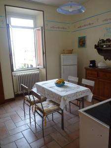代森扎诺-德尔加达Appartamento palazzo del Provveditore vista lago的厨房配有桌椅和窗户。