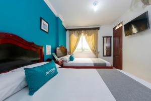 波帕扬Ayenda La Terraza Popayán的一间卧室设有两张床和蓝色的墙壁