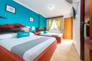 波帕扬Ayenda La Terraza Popayán的一间卧室设有两张床和蓝色的墙壁