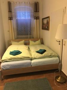 约翰乔治城Ferienwohnung Franke EG RuheZeit am Schwarzwasser的一间卧室配有一张带两张绿毛巾的床