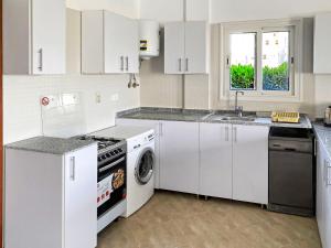阿莱曼Your Go-to Place at Amwaj, North Coast for Summer!的厨房配有白色橱柜、洗衣机和烘干机