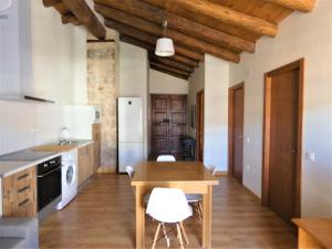 贝塞特Casa Tropiet的厨房配有木桌和白色椅子