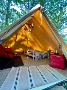 波讷地区圣朱利安Tente Indiana Chênes - La Téouleyre的帐篷配有一张床和一张桌子