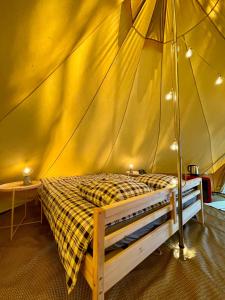 波讷地区圣朱利安Tente Indiana Chênes - La Téouleyre的帐篷内一间卧室,配有一张床
