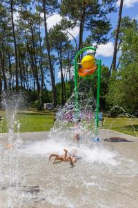 波讷地区圣朱利安Tente Indiana Chênes - La Téouleyre的两个人在公园的喷泉里玩耍