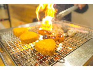 下关Pensione Shimado - Vacation STAY 37555v的金属烤架,上面有食物,有火焰