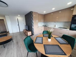 希奥利艾2-bedrooms apartment in city center Šiauliai的厨房配有木桌和绿色椅子