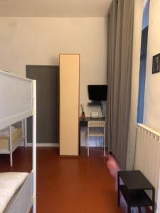 佛罗伦萨Short Stop Room的客房设有一张床、一张书桌和电视