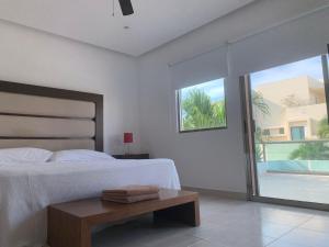 坎昆Cancún Airport Zone的一间卧室配有一张床、一张桌子和一个窗户。