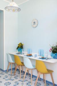 卡梅罗塔码头B&B Margherita 2的一间设有白色桌子和黄色椅子的用餐室