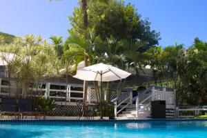 库莱布拉斯博奈俱乐部酒店的一个带遮阳伞和椅子的游泳池以及树木