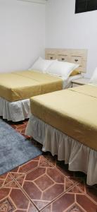 科马亚瓜APARTAMENTOS CASCO HISTORICO COMAYAGUA的三个床在一间房间里排成一排