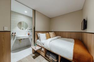悉尼Aerotel Sydney (Arrivals B, International Terminal 1)的一间卧室配有一张床、一个水槽和淋浴
