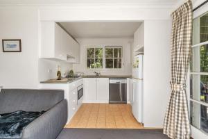 袋鼠谷Alcheringa Cottage Amazing Location with views的一间厨房,内设白色橱柜和沙发