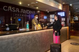 利马米拉弗洛雷斯安迪纳高级酒店的带着行李站在酒吧的女人