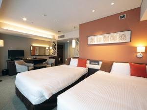 鸟取市摩那趣鸟取酒店的酒店客房配有两张床和一张书桌