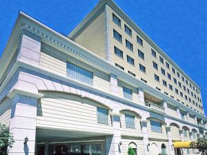 鸟取市摩那趣鸟取酒店的一座白色的大建筑,有很多窗户