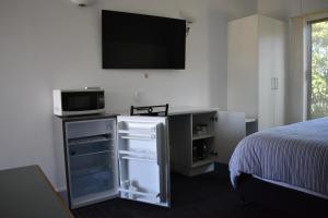 德尼利昆里维亚那汽车旅馆的卧室配有一张床,墙上配有电视。