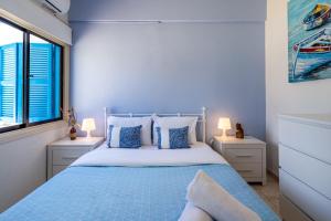 皮拉Sea Breeze 1-BR Apt in Pyla的一间蓝色卧室,配有床和2个窗户