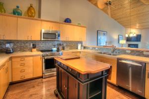洋滨市Vista Del Mar Condo - Oyhut Bay Seaside Village的一个带木制橱柜和不锈钢用具的大厨房
