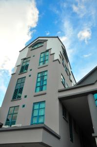 Kuala Belait达广场酒店 的一座高大的白色建筑,上面有窗户